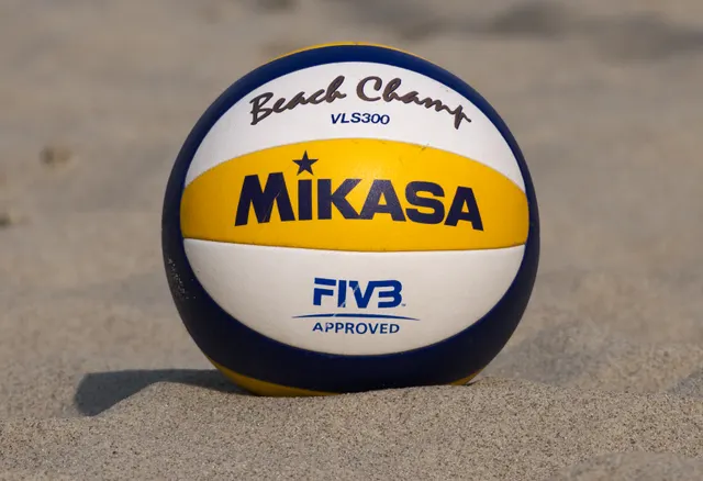A Mikasa VLS300 beach volleyball resting on sand